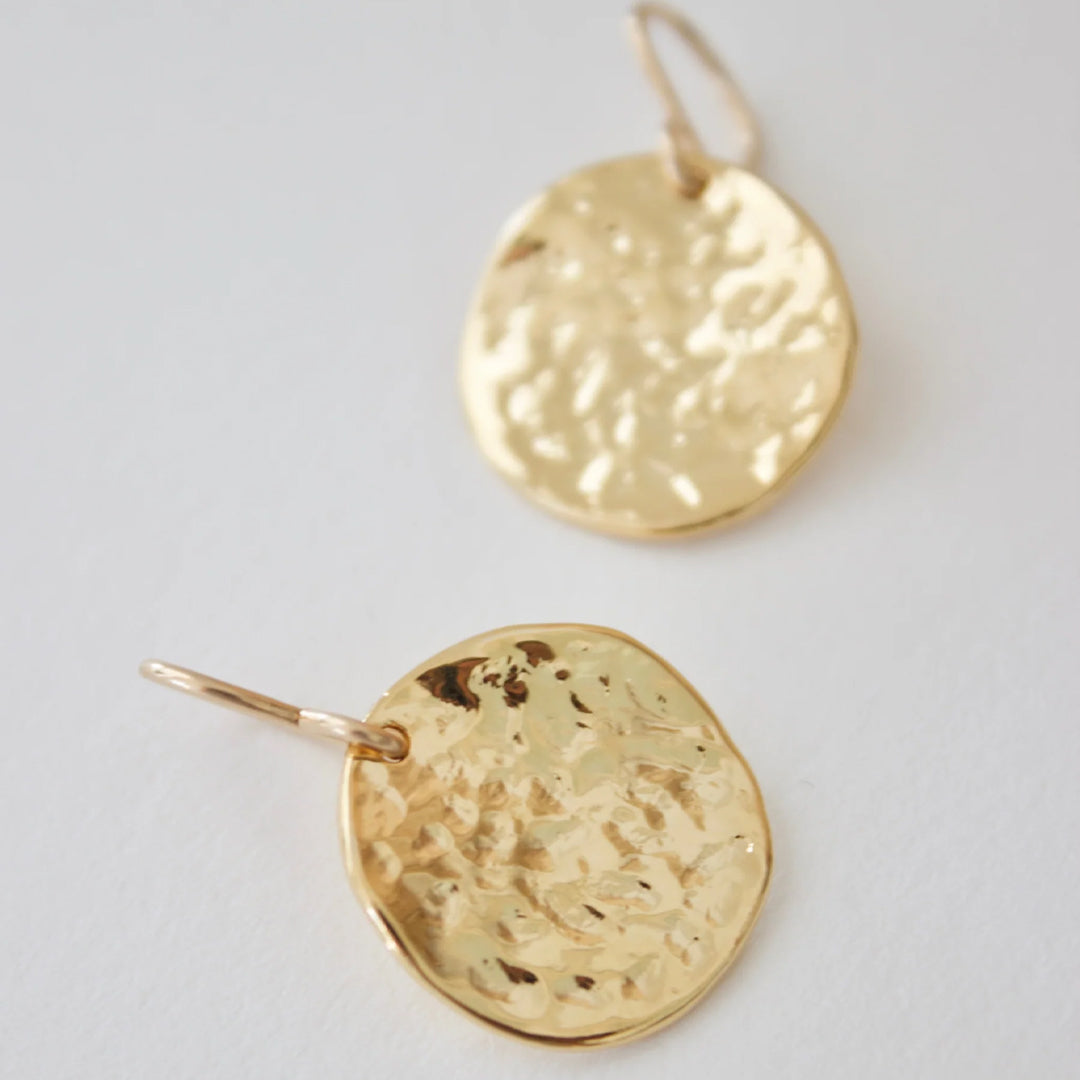 Gold hammered medallion earrings by Katie Waltman featuring textured round medallions on delicate ear hooks.