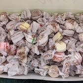 Assorted Marinis Salt Water Taffy pieces in colorful wrappers, featuring the Marinis Candy brand on the packaging.