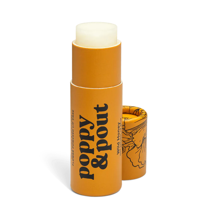 Poppy & Pout 100% natural wild honey lip balm in a small tube, showing smooth, hydrating balm on the applicator.